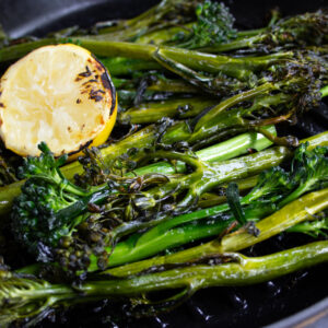Grilled broccolini with a charred lemon wedge.