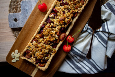 Cherry tart on a wood board.