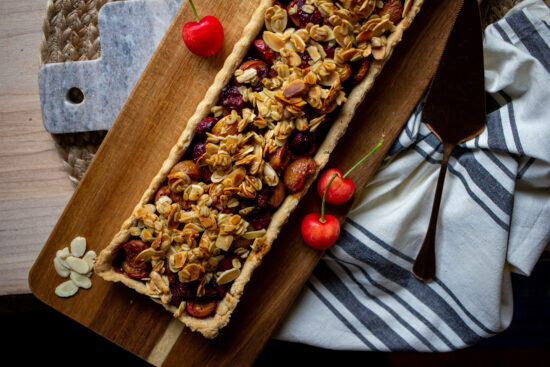 Cherry tart on a wood board.