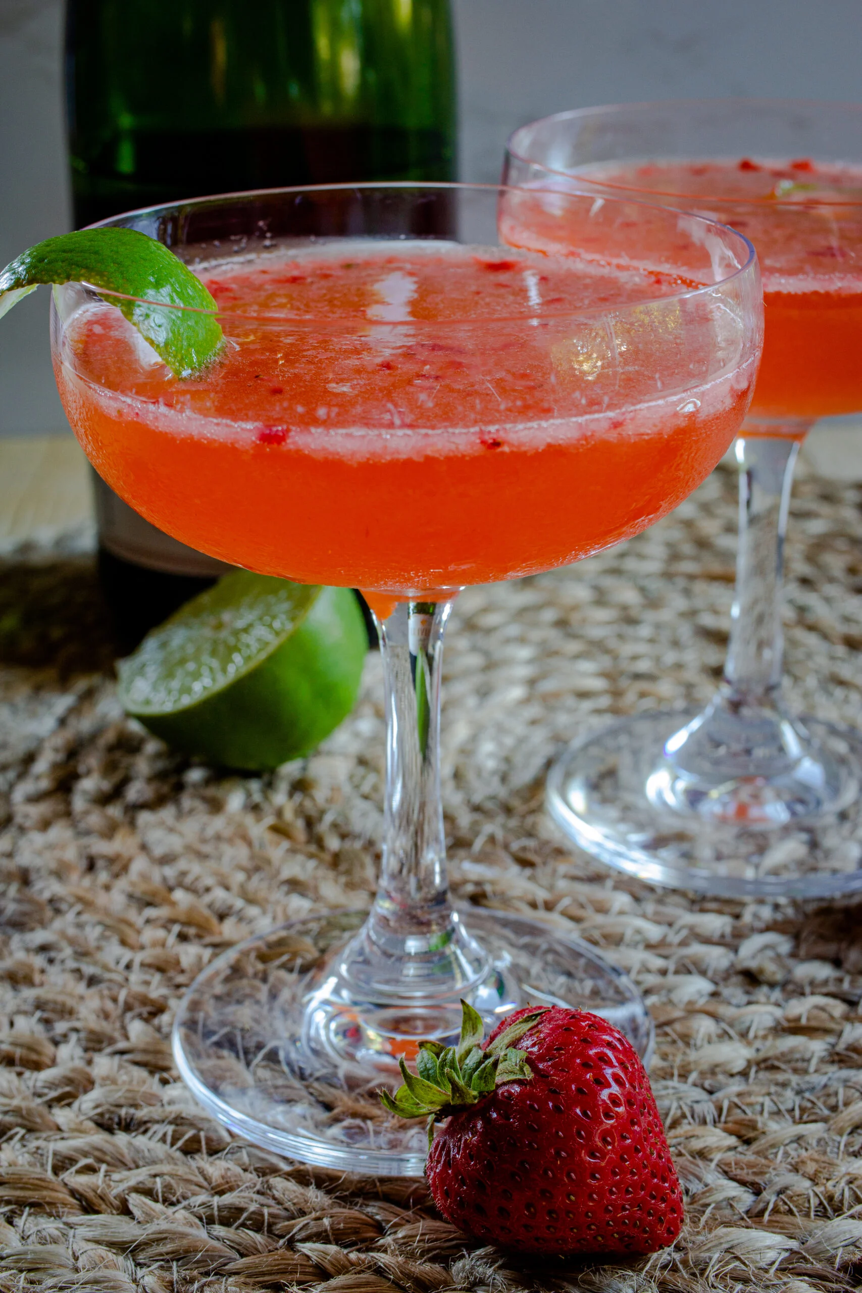 Cocktail in a coupe glass with lime garnish.
