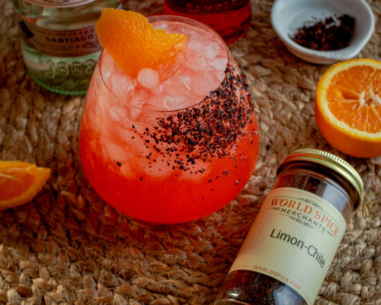 Cocktail next to a container of spices.