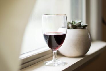 Glass of wine on a window ledge.