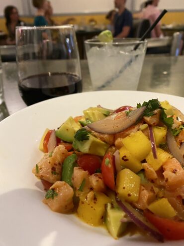 Bowl of ceviche and a glass of wine.
