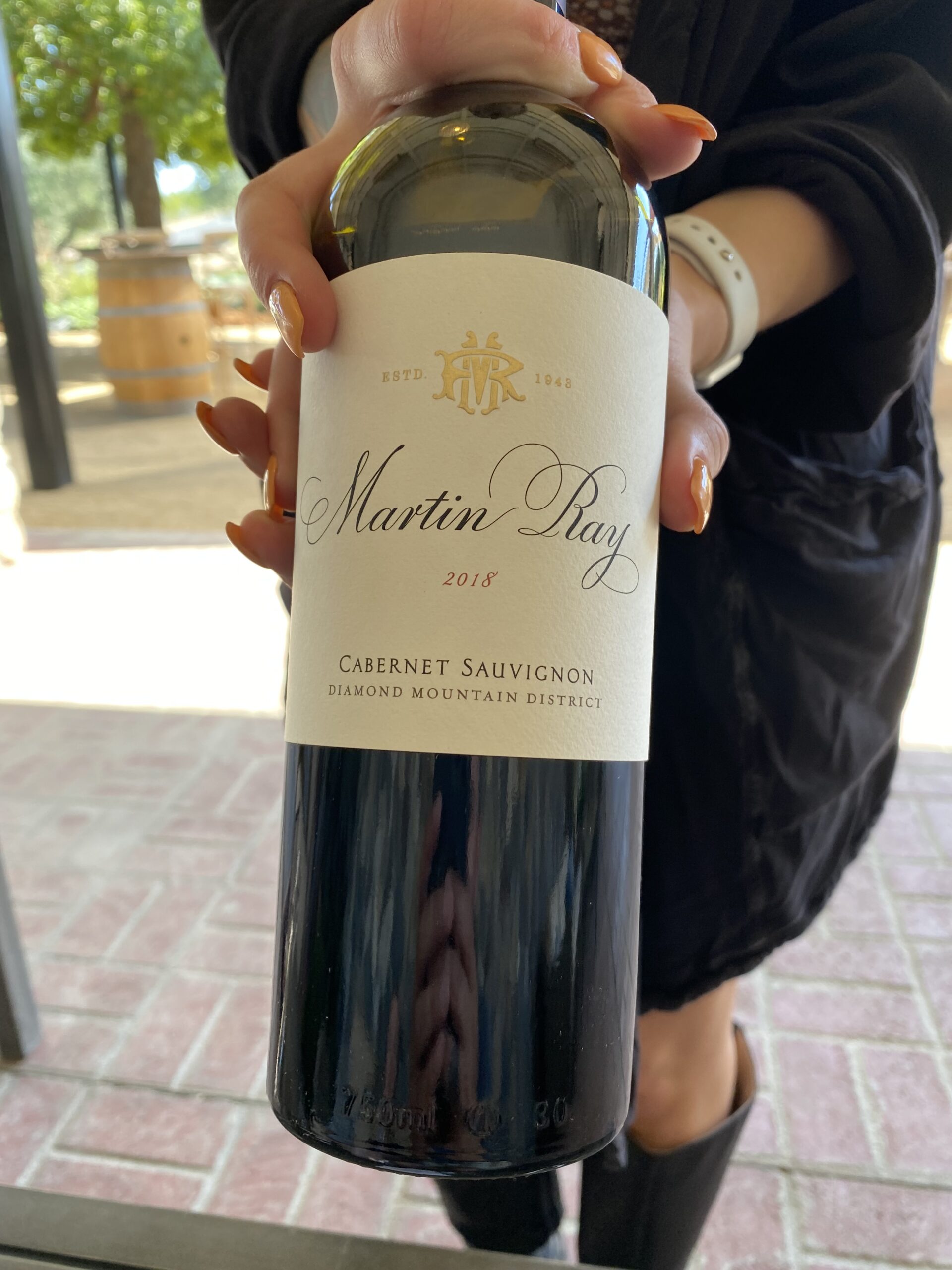 Hands holding a bottle of red wine from Martin Ray Winery
