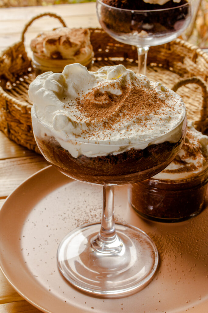 Clear cocktail class with dark chocolate mousse and whipped cream.