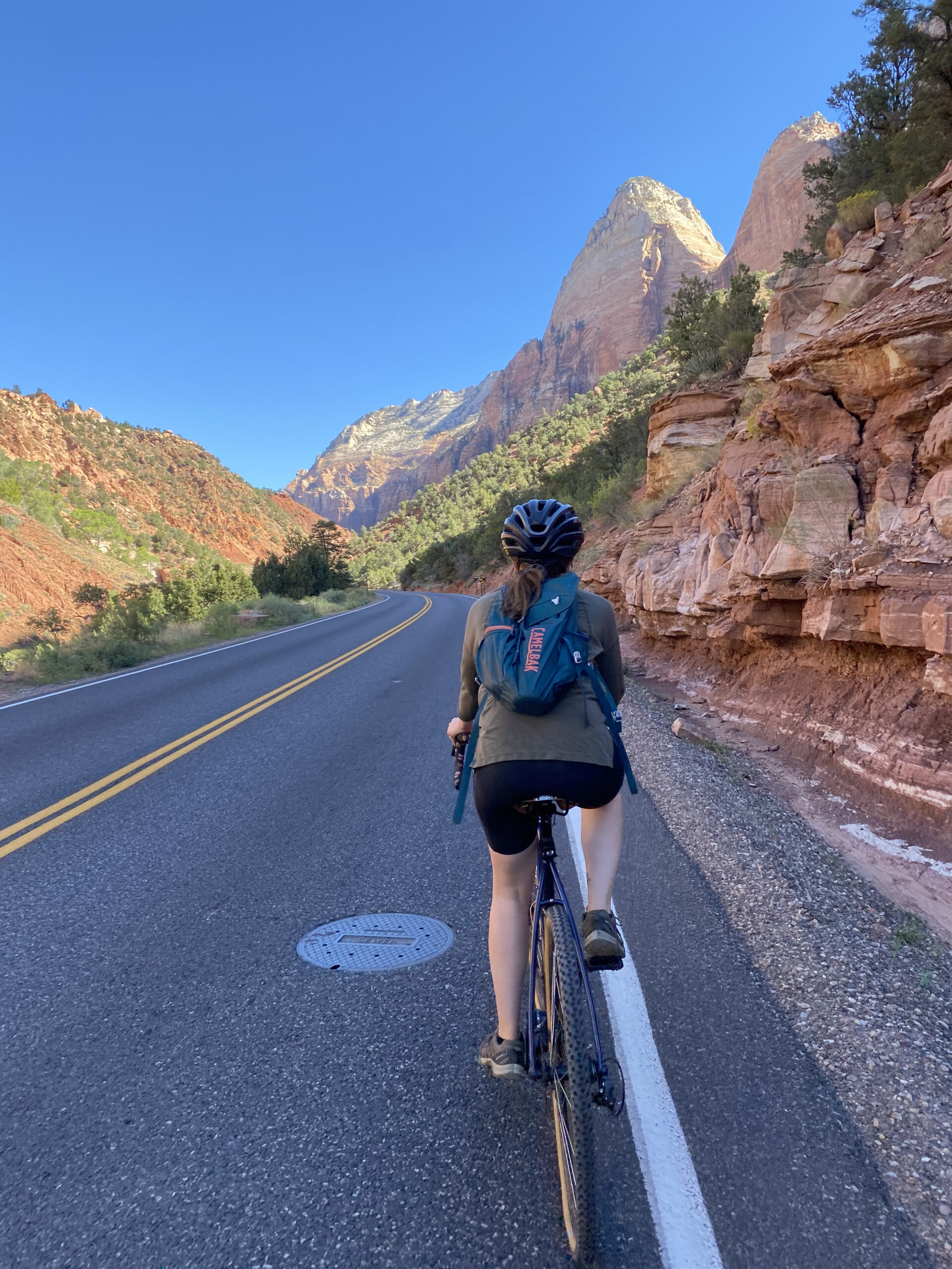 Girl with backpack biking in Zion.