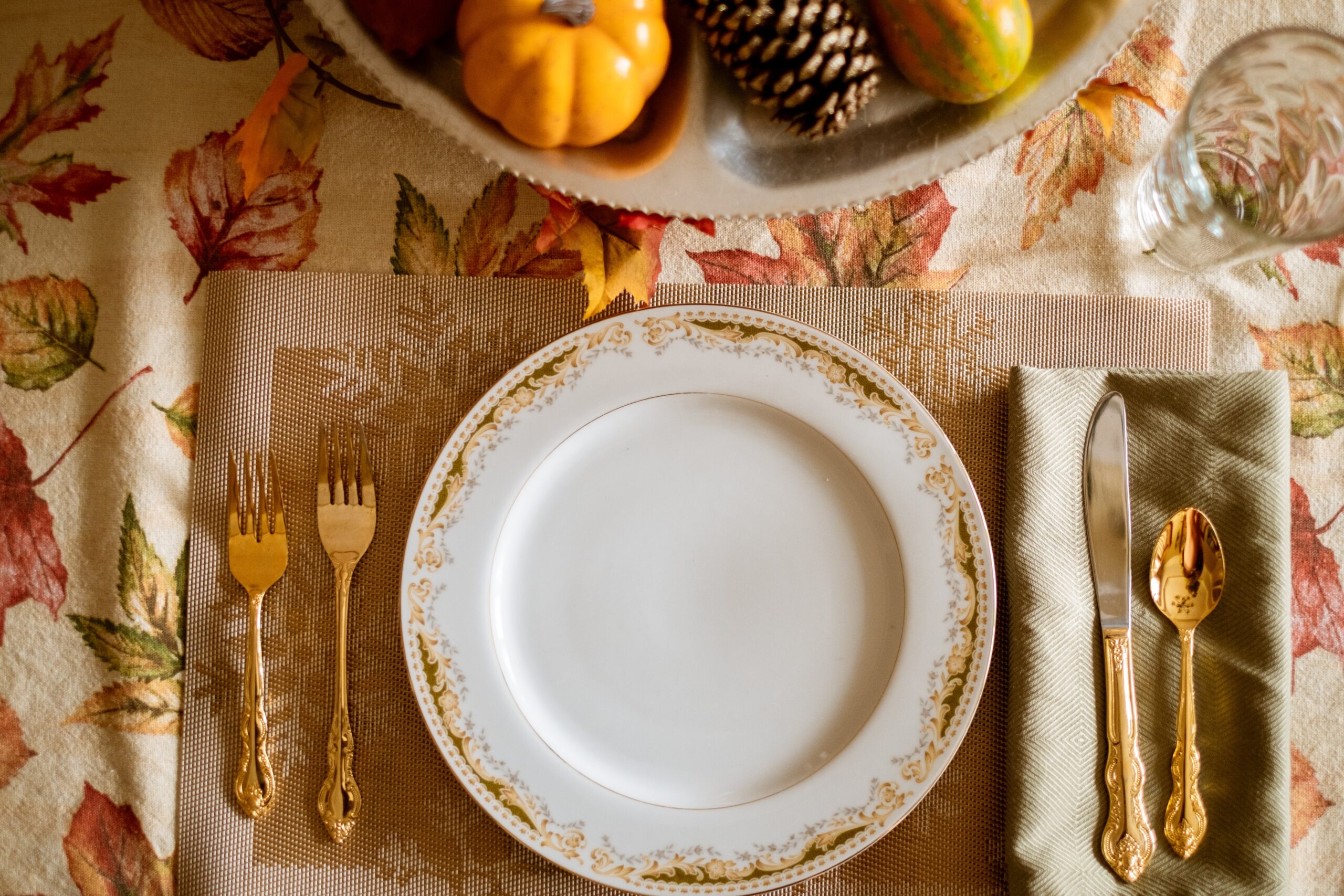 Set of china on table with autumn leave tablecloth.
