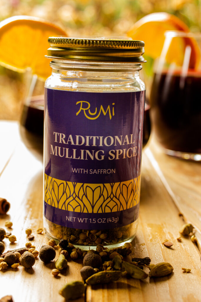 A jar of mulling spices with the spices spilled out in front of the jar.