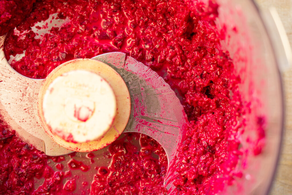 Close up of a food processor filled with blended beets.