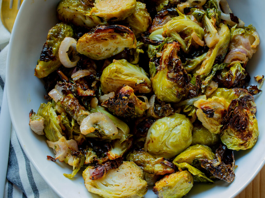 Close up of air fryer brussels sprouts with sliced shallots.