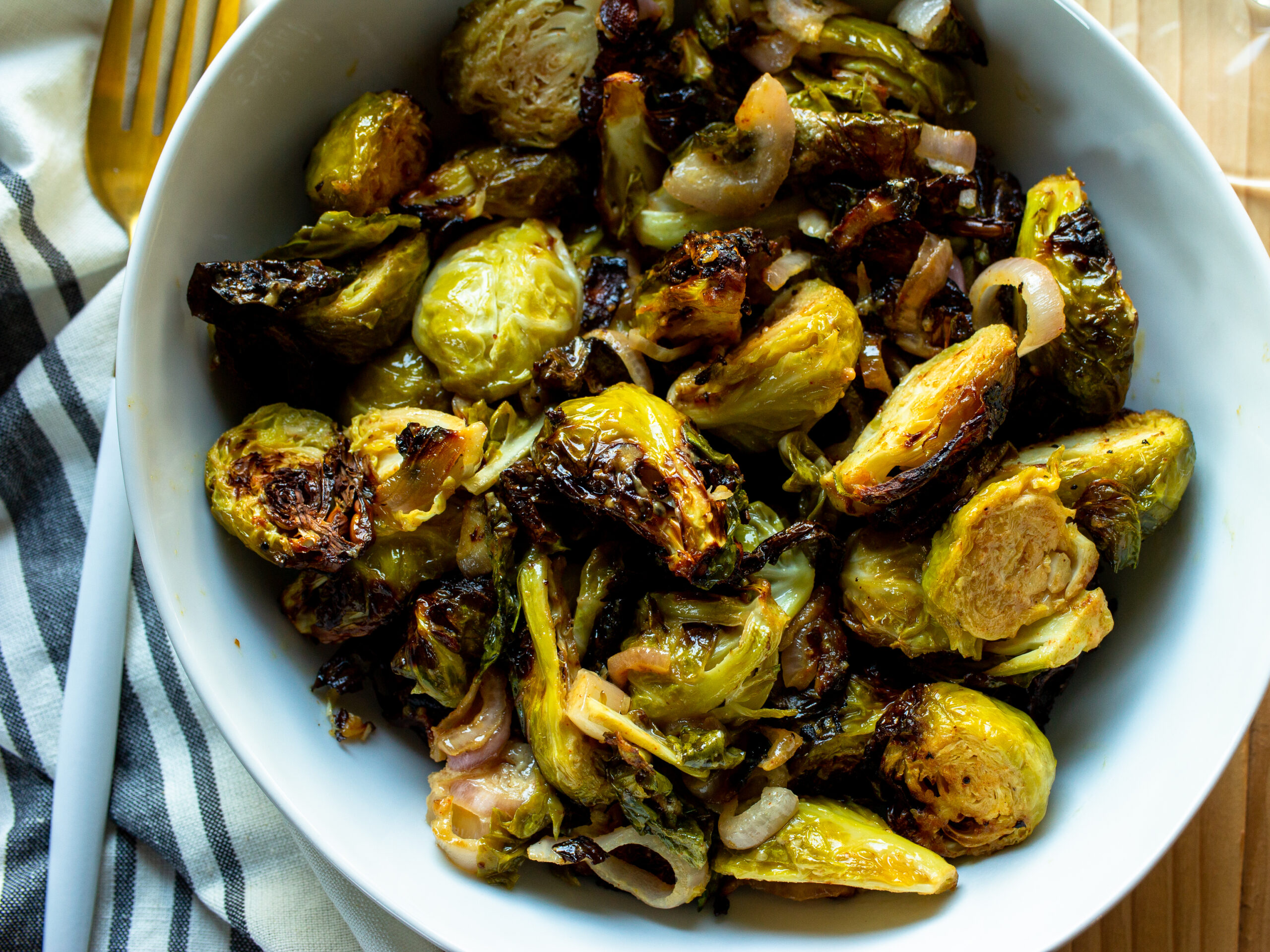 Close up of air fryer brussels sprouts with sliced shallots.