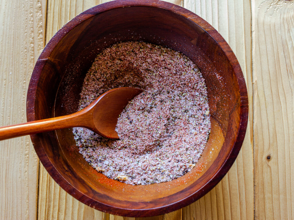 Seasoning salt in a wooden bowl with a wooden spoon in the bowl.