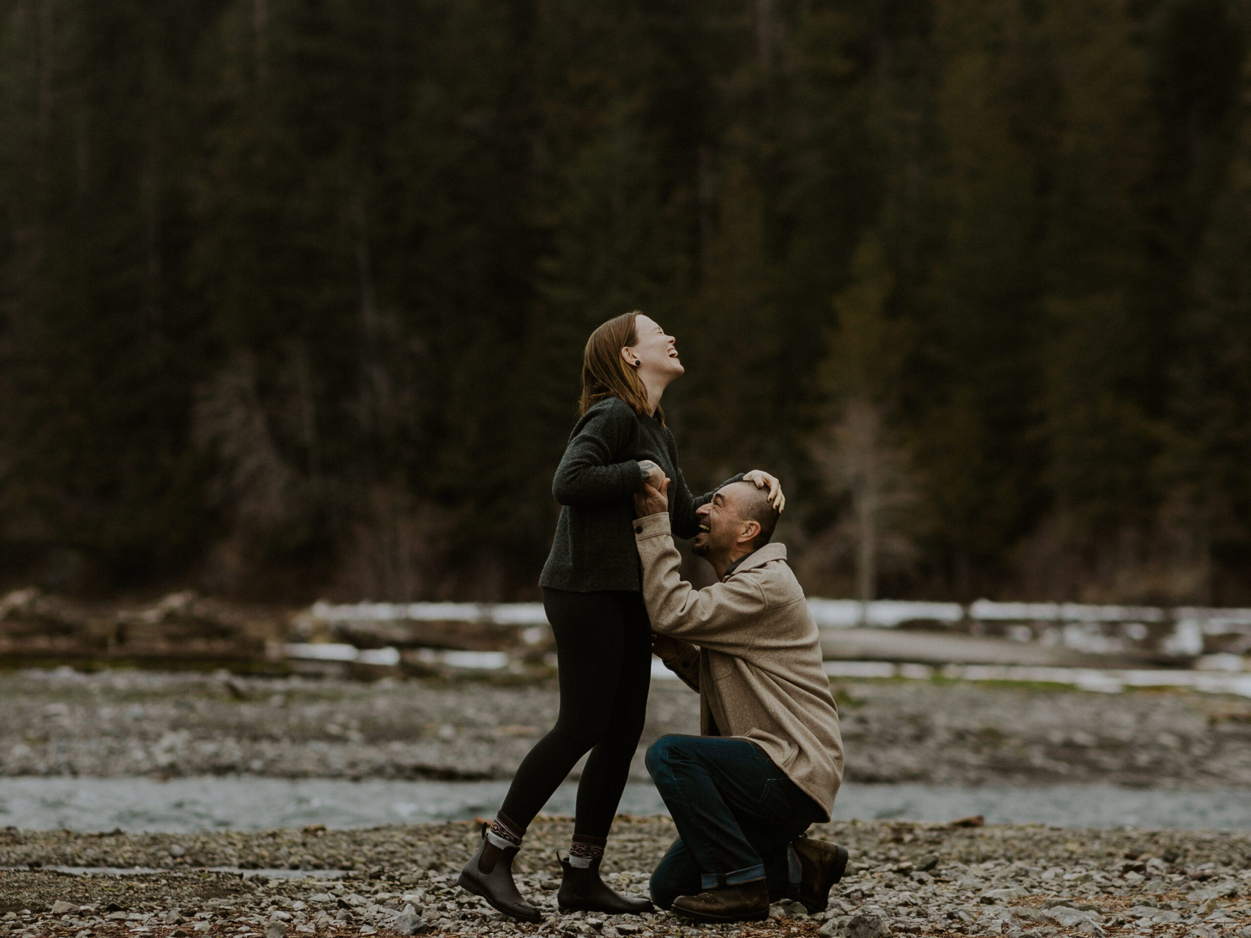 A couple embracing in the woods.