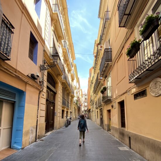 A woman walking down a village street.